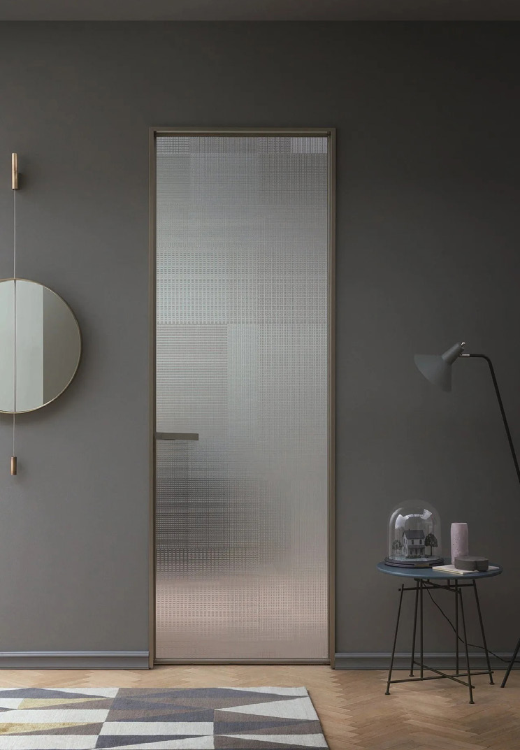 Full-height frosted glass bathroom door in a dark interior