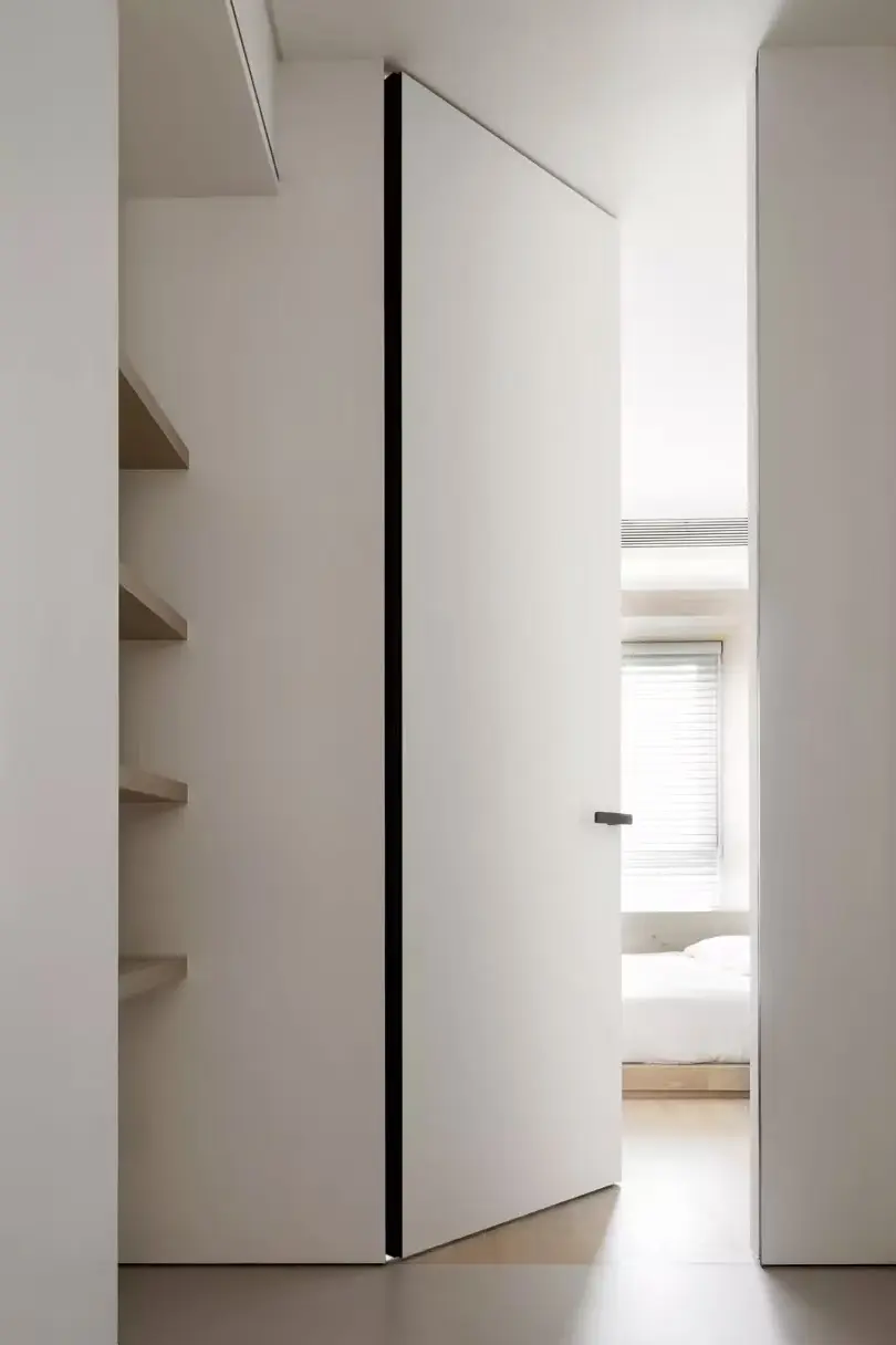 White invisible door open within a flush wall composition