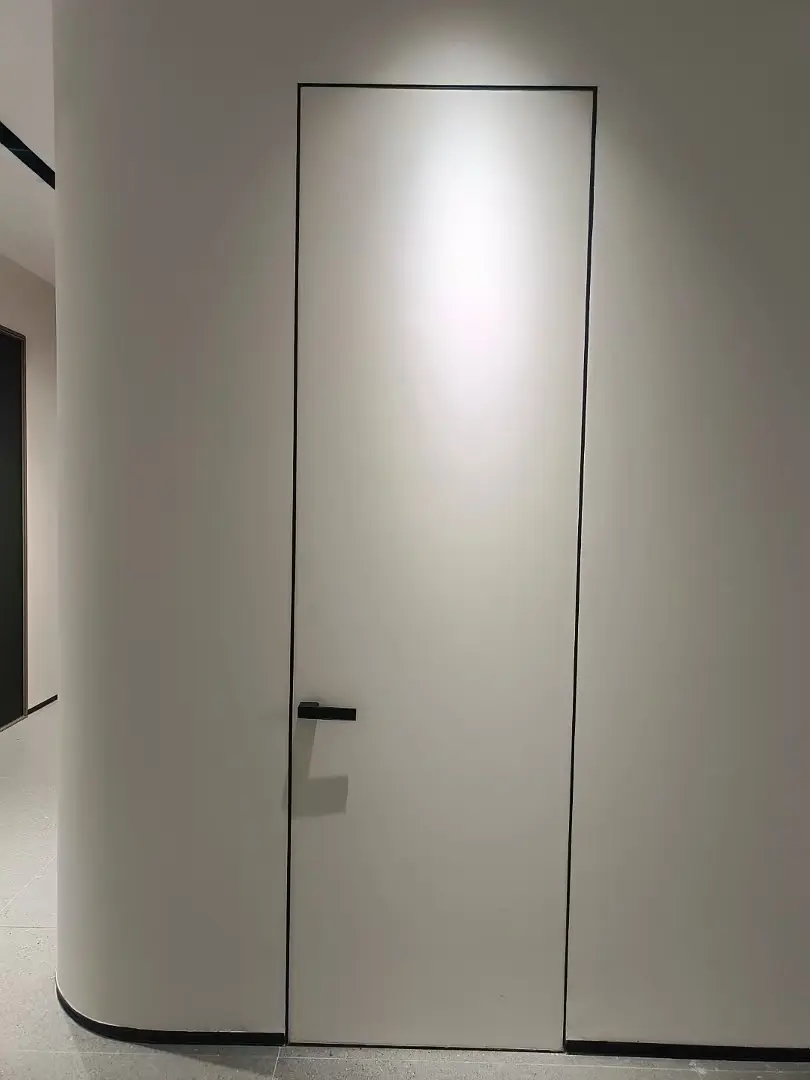 Full-height white invisible door set into a curved plaster wall