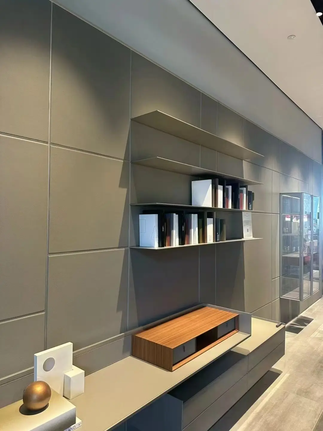 Panelled media wall with floating shelves, low cabinetry and integrated lighting