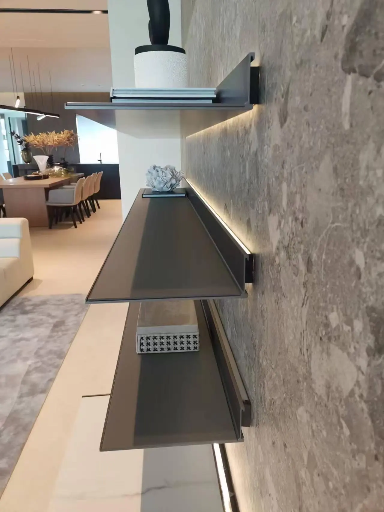 Side detail of wall-mounted shelves and concealed linear lighting