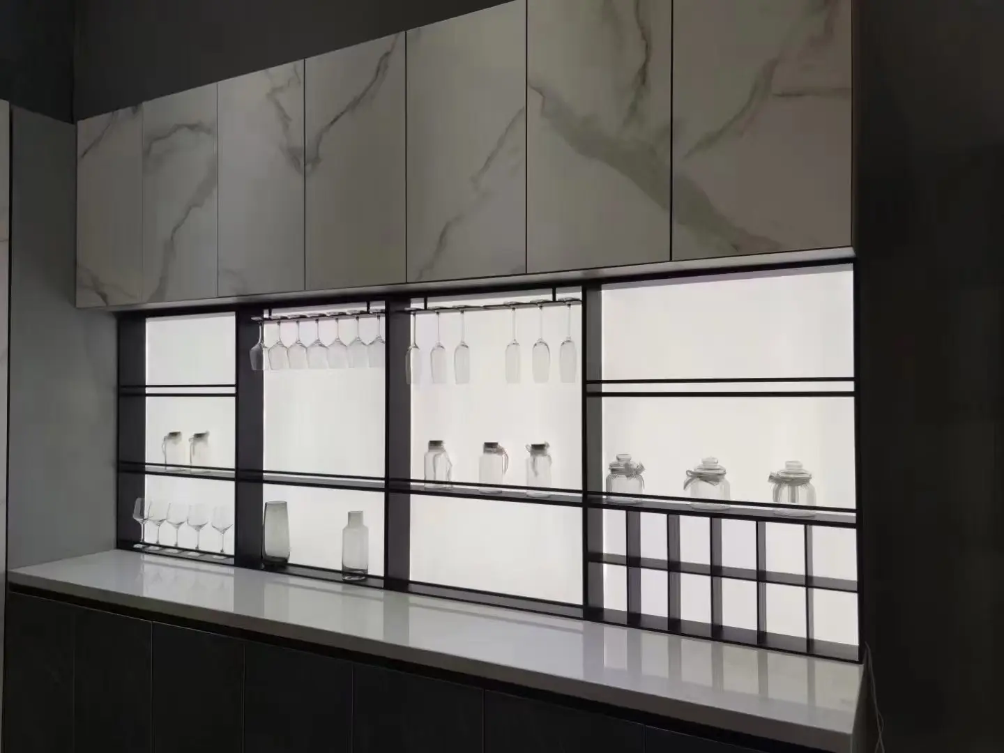 Backlit wine and glassware display integrated into cabinetry