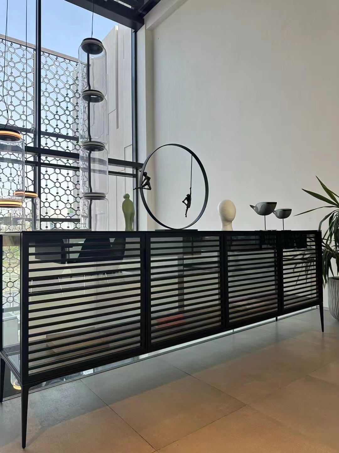 Long glass sideboard with black horizontal louvre fronts