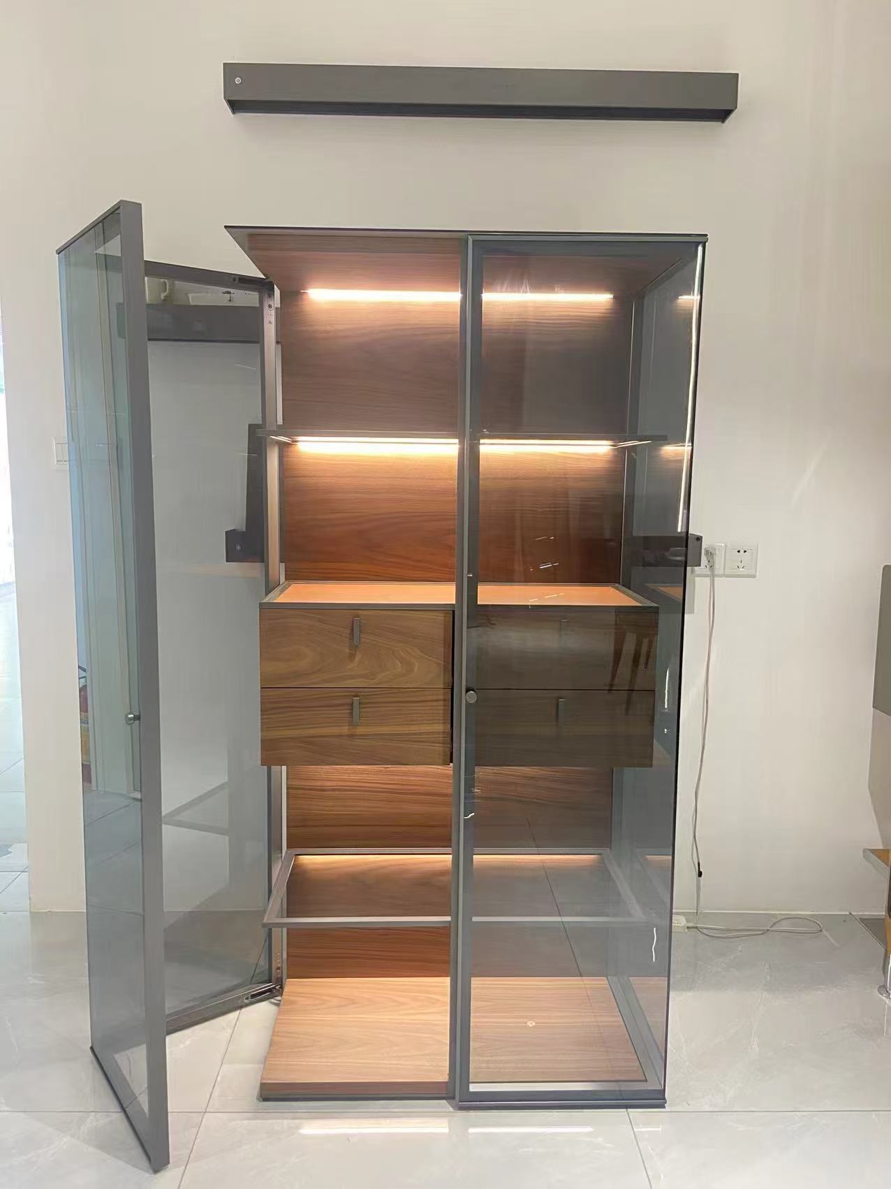 Tall illuminated glass cabinet with walnut drawers