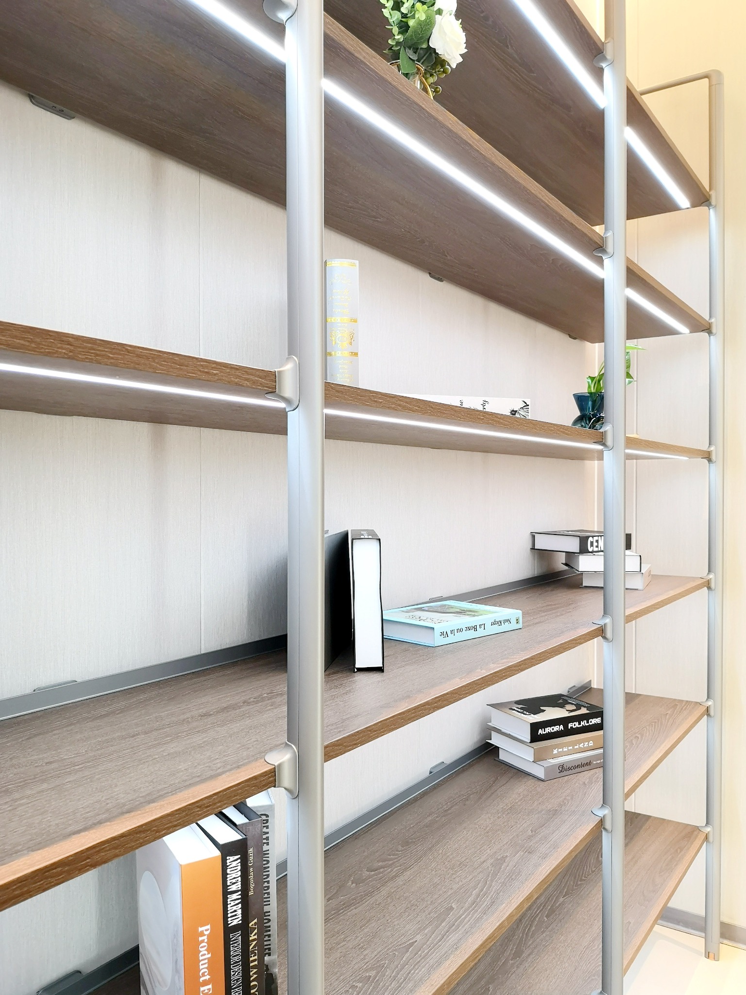 Close view of illuminated timber shelves on round uprights