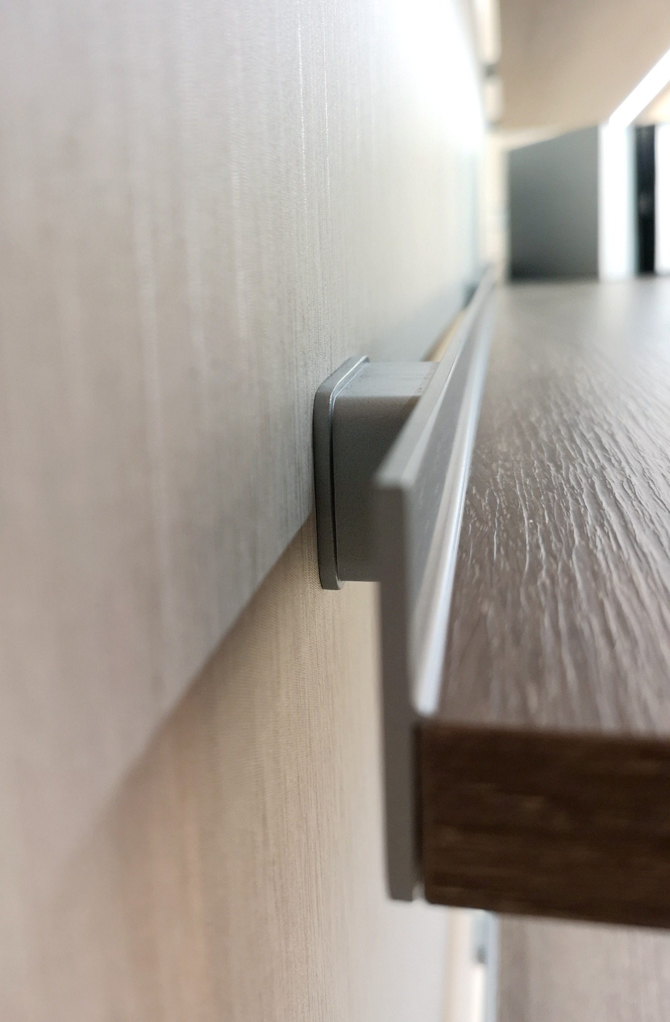 Close-up of hidden wall rail supporting a timber shelf