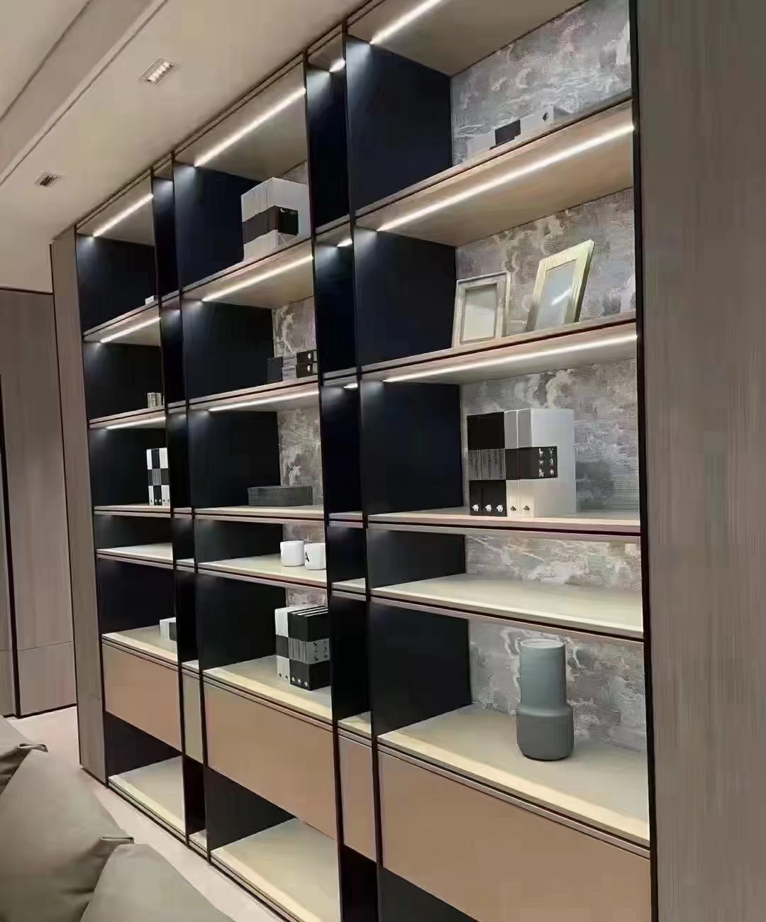 Wall-to-wall shelving with illuminated bays and suspended cabinets